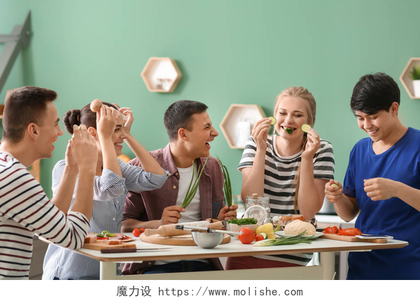 绿色背景下吃着美食的年轻人年轻的朋友在厨房做饭时玩得开心